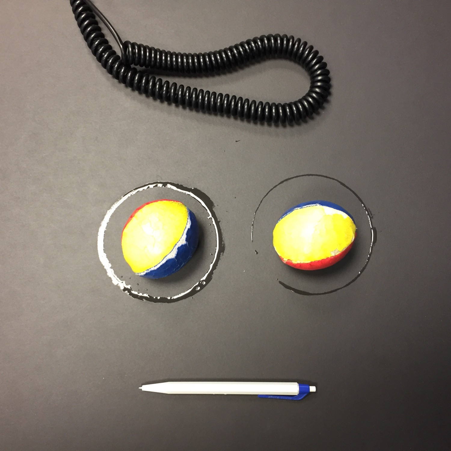 A face made of water and other items from my desk.
