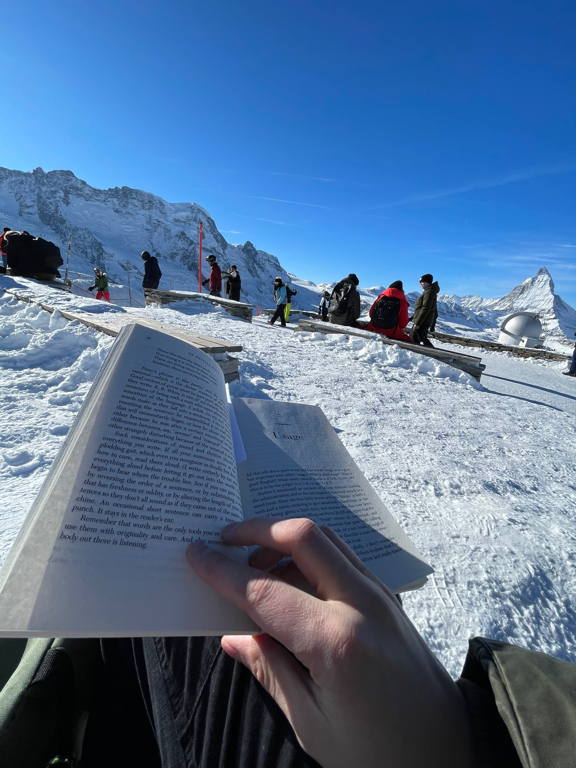 What makes a good book even better? Reading it outside on top of a mountain with snow and sun. And you just see the Matterhorn on the right side of the image. 📚
