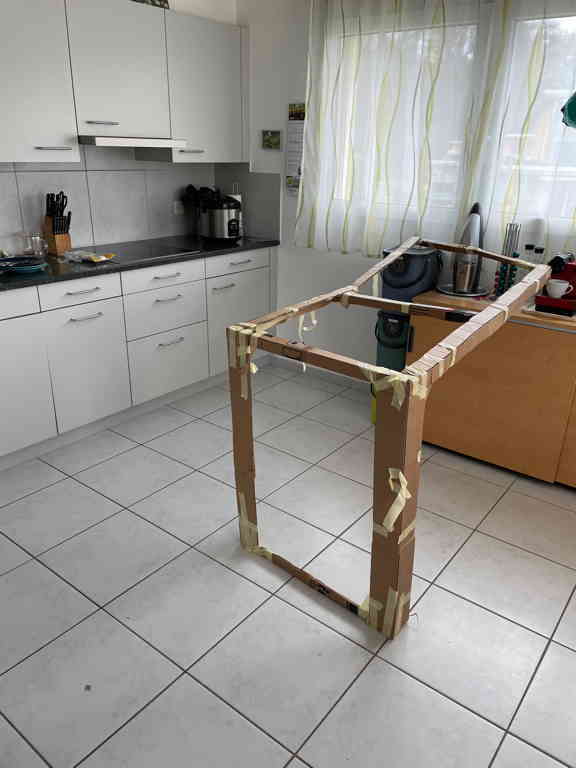 Testing how a potential kitchen island would look in our kitchen with a cardboard mockup.
