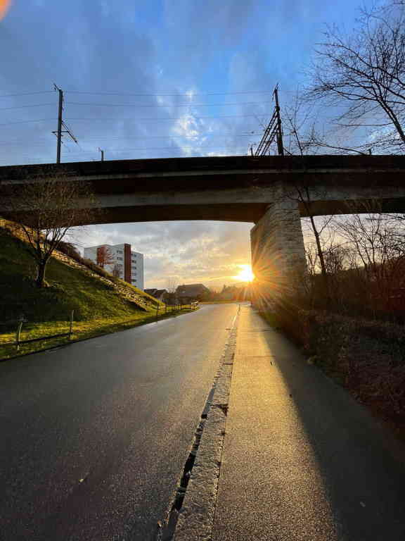 Railwail bridge with evening sun behind it after a short rain.
