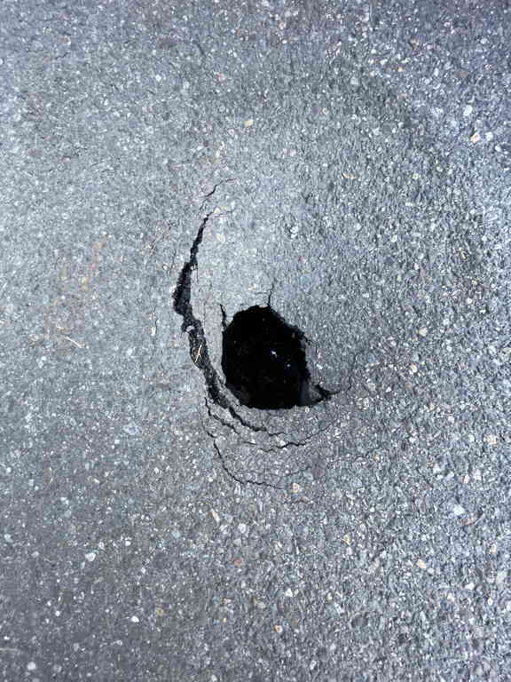 Closeup of the sinkhole in the pavement.