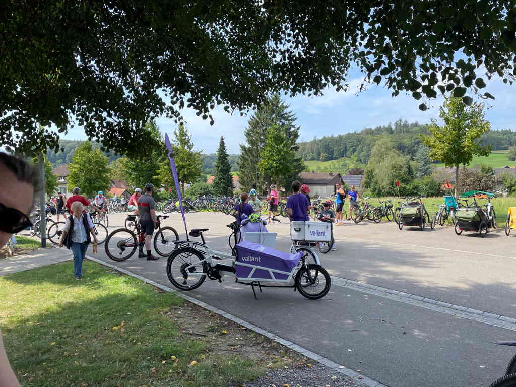 Wide shot of the street. Closed for cars and full of bicycles. In the center is a cargo bike from one of the event sponsors (Valiant - a Swiss bank). They were distributing branded sweets. 