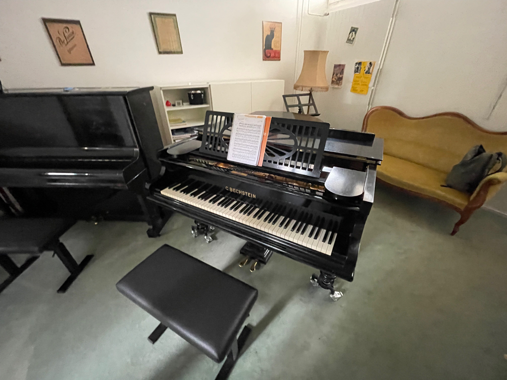 In the center Of the picture is the grand piano I practice on. To the left is the regular piano used by the teacher.