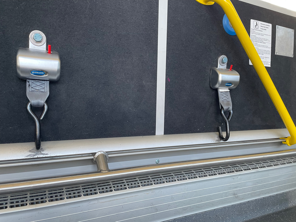 A closeup image of two safety belts for wheelchairs in our bus.