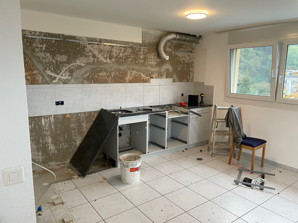 Picture of our old kitchen. Most of the cabinets are removed. There is still the old backsplash visible.