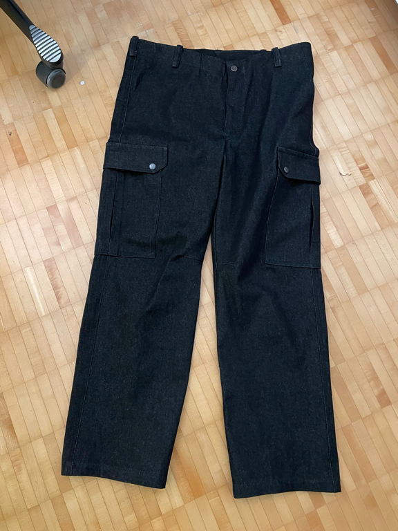 Black jeans on the floor. These are cargo pants with additional pockets on the legs.